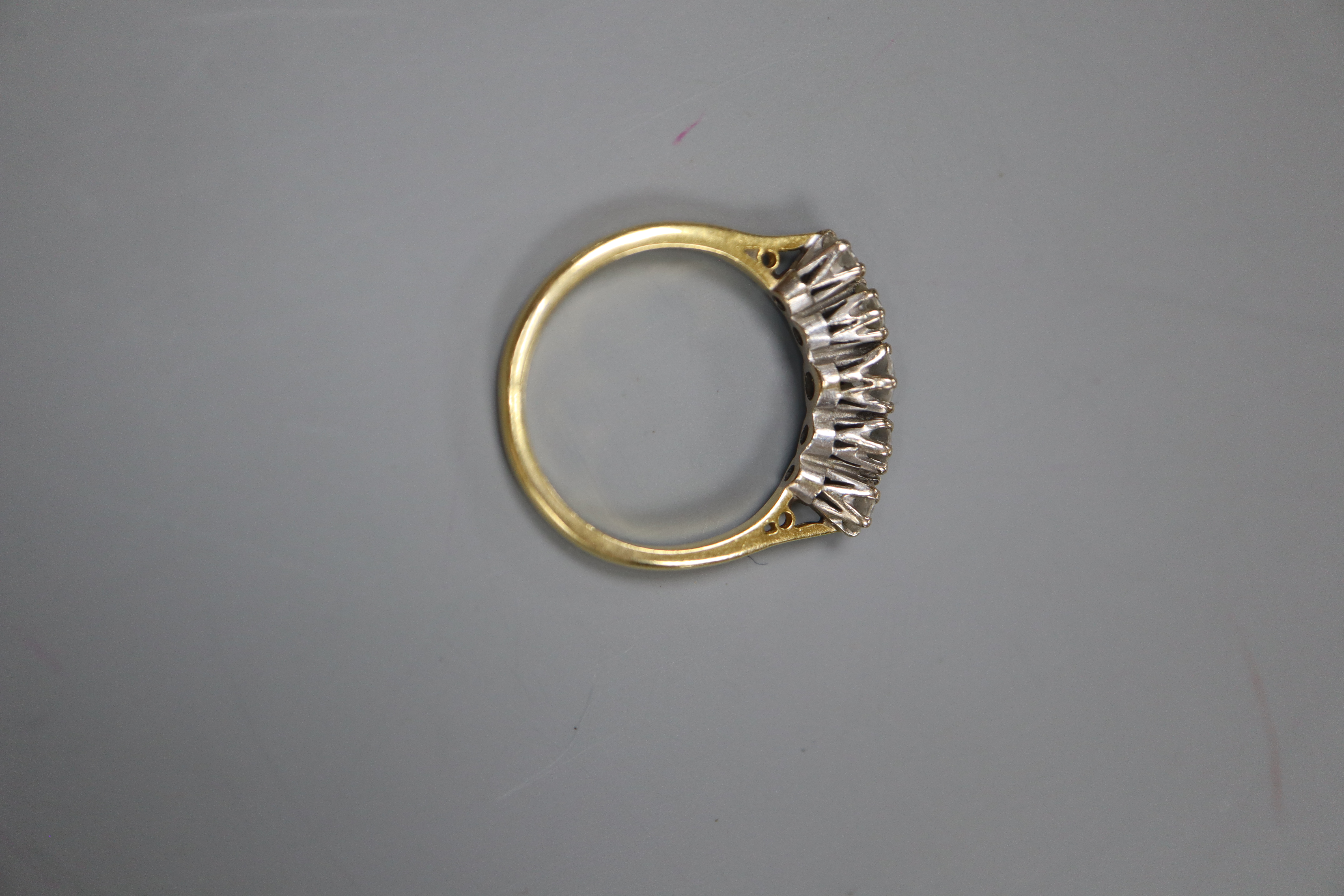 An 18ct and graduated five stone diamond set half hoop ring, size O, gross 3.6 grams.